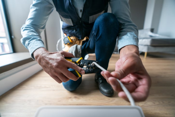 Broadband service worker installing an internet modem. 